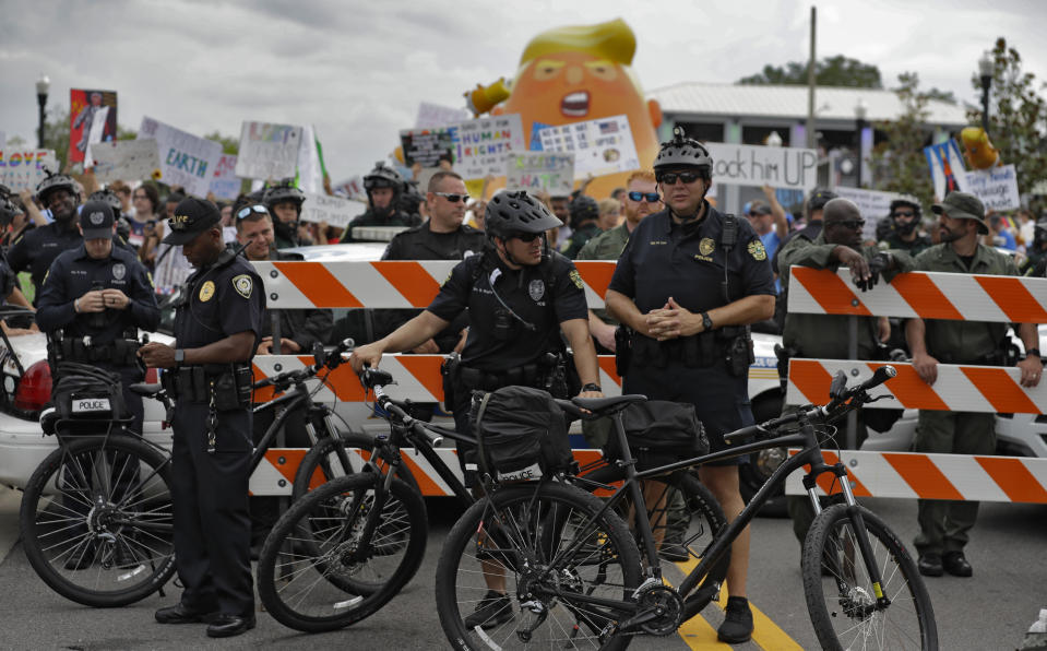 Police officers block a street during a rally against President Donald Trump Tuesday, June 18, 2019, in Orlando, Fla., near where Trump was announcing his re-election campaign. (AP Photo/Chris O'Meara)