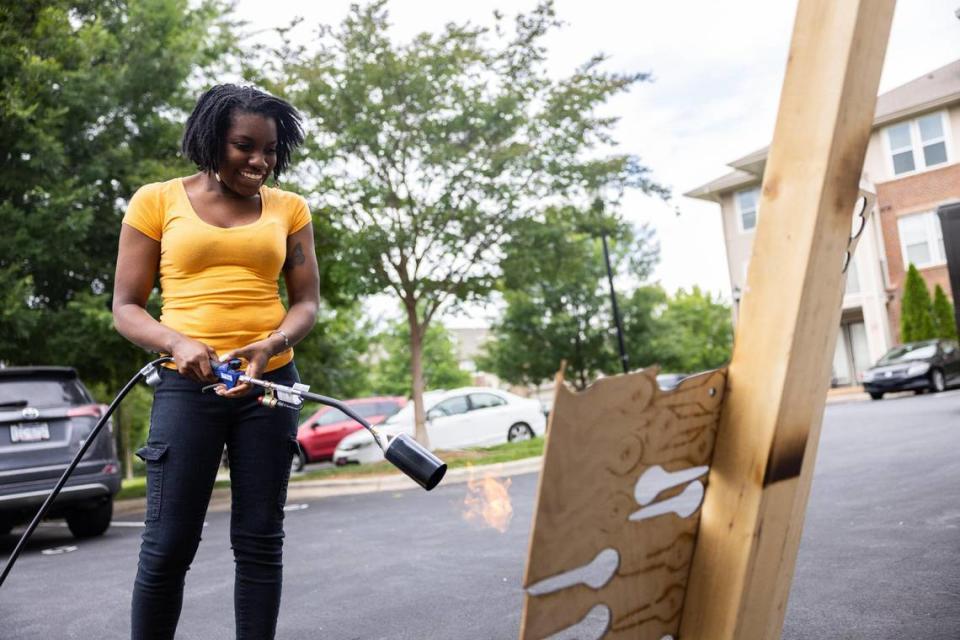 Nadia Meadows uses her blow torch outside her garage studio in Charlotte. The torch helps her to continue creating sculptures that capture attention, push boundaries and inspire conversations.