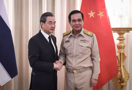 Chinese Foreign Minister Wang Yi (L) shakes hands with Thai Prime Minister Prayuth Chan-O-Cha (R) at Government House in Bangkok, Thailand July 24, 2017. REUTERS/Lillian Suwanrumpha/Pool