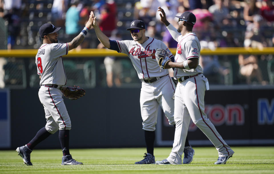 From left, Atlanta Braves left fielder Eddie Rosario, center fielder Adam Duvall and right fielder Jorge Soler celebrate after the ninth inning of a baseball game against the Colorado Rockies Sunday, Sept. 5, 2021, in Denver. The Braves won 9-2. (AP Photo/David Zalubowski)