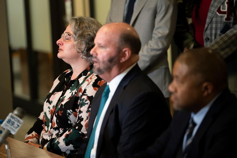 Rebecca Duran, Donovan Lewis' mother, closes her eyes while attorney Rex Elliott, center, speaks Thursday during a press conference at Cooper Elliott Law Offices announcing a lawsuit against Columbus police officer Ricky Anderson, who shot the 20-year-old Lewis, and four other officers. At right is Dayton-area attorney Michael Wright, who is also part of the legal team that filed the lawsuit.