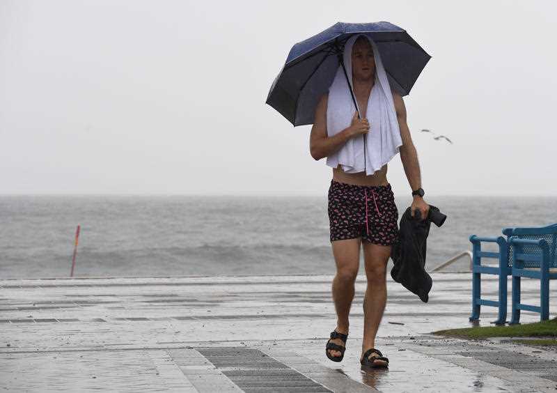 A pedestrian holds an umbrella during heavy rain in Coogee, Sydney.