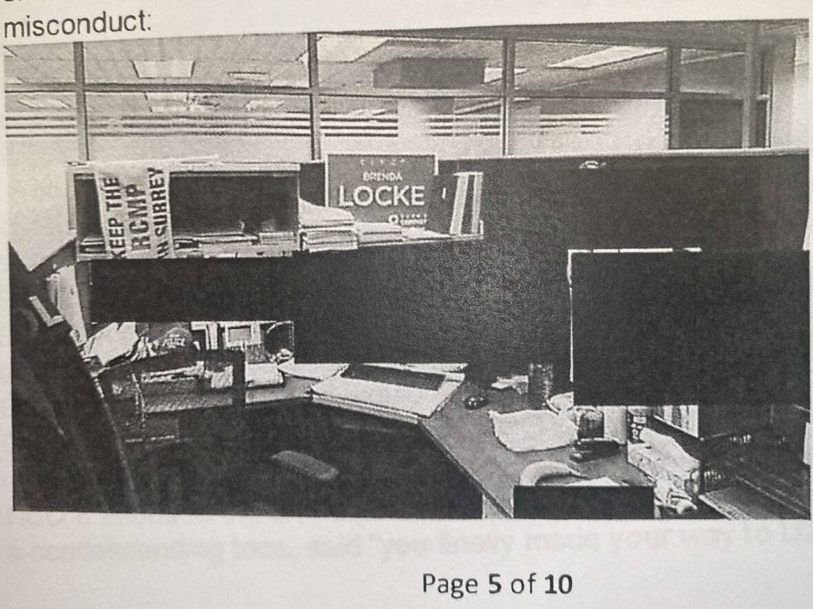 A photograph included in an investigative report detailing allegations of harassment by RCMP officers against Surrey Police Service members shows the workplace of a senior officer who had a 'Keep the RCMP in Surrey' sign on his desk as well as an election sign for Mayor Brenda Locke. (B.C. Supreme Court - image credit)