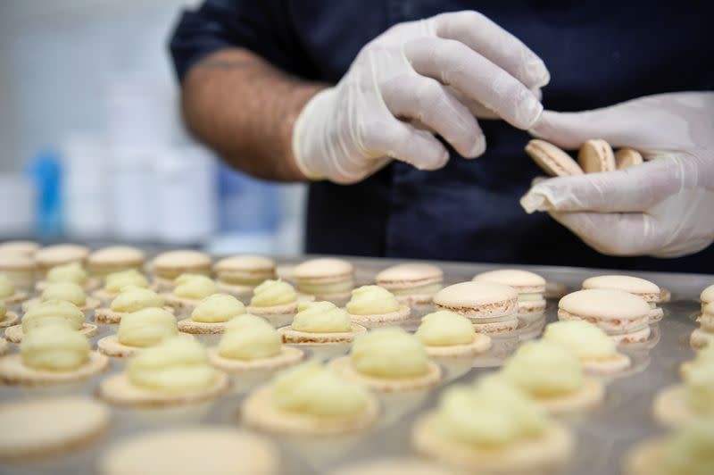 A worker prepares a macaron at the workshop of Belgian chocolate maker Marcolini, in Brussels