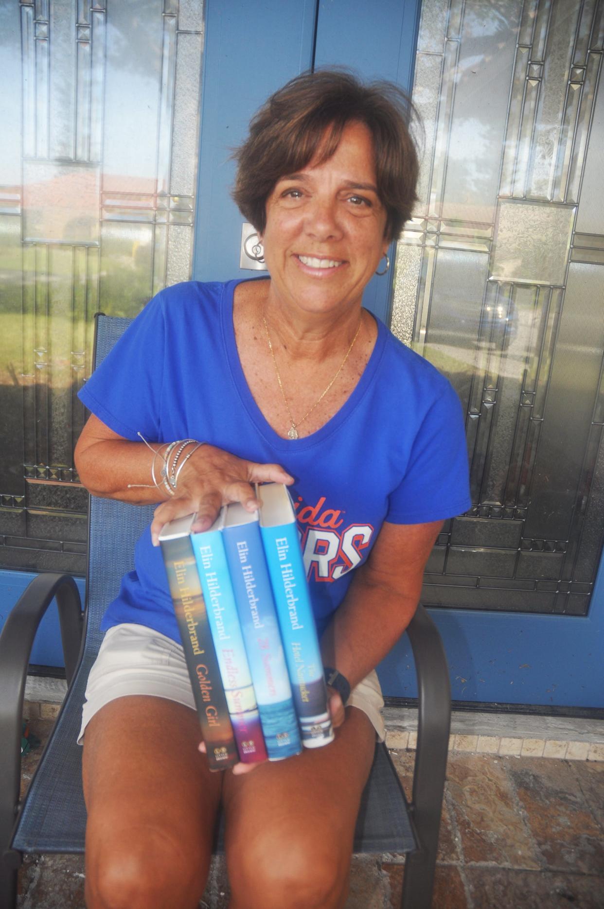 Jayne Klinker sits on the stoop of her Bonita Springs home holding the four Elin Hilderbrand books that were donated to her by the publisher. Her favorite book was autographed by the author. 