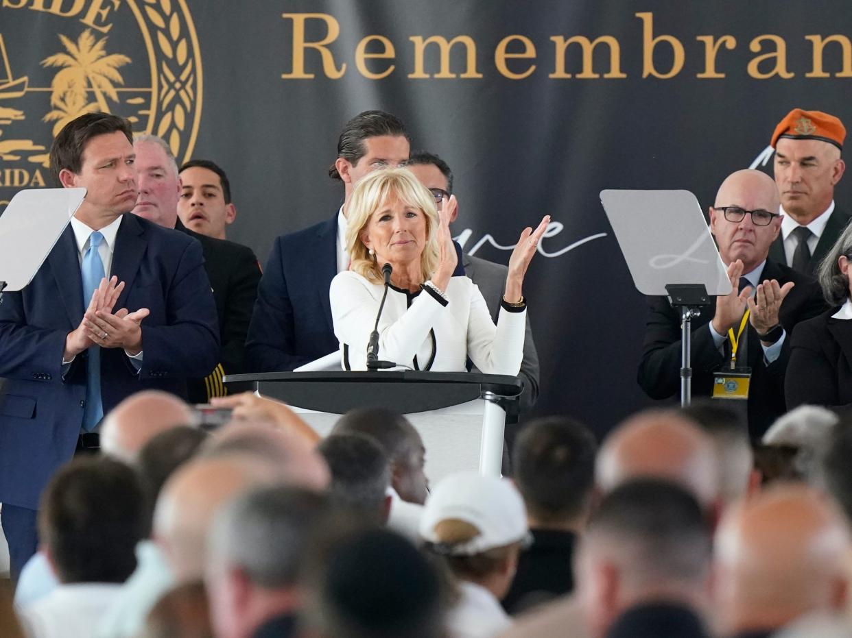 First lady Jill Biden, center, leads a round of applause for first responders during a remembrance event at the site of the Champlain Towers South building collapse, Friday, June 24, 2022, in Surfside, Florida.