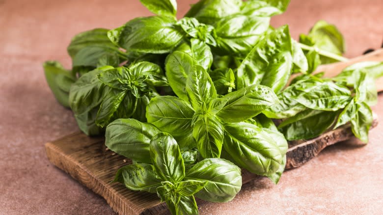 Basil leaves on wooden board