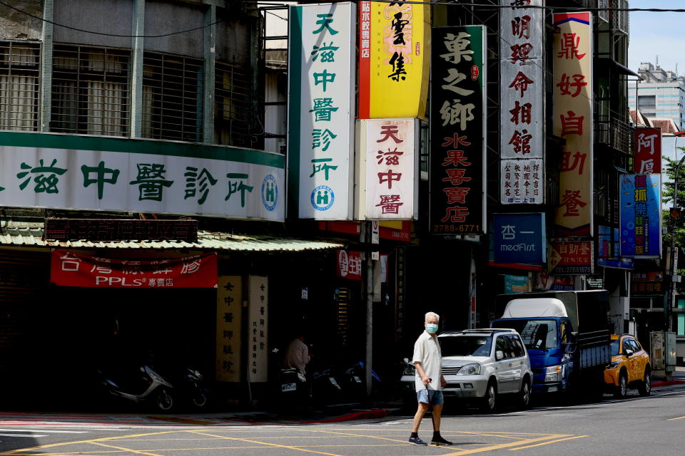 A man crosses the street while wearing a protective mask following the recent rise in coronavirus disease (COVID-19) infections in Taipei, Taiwan June 2, 2021. REUTERS/Ann Wang