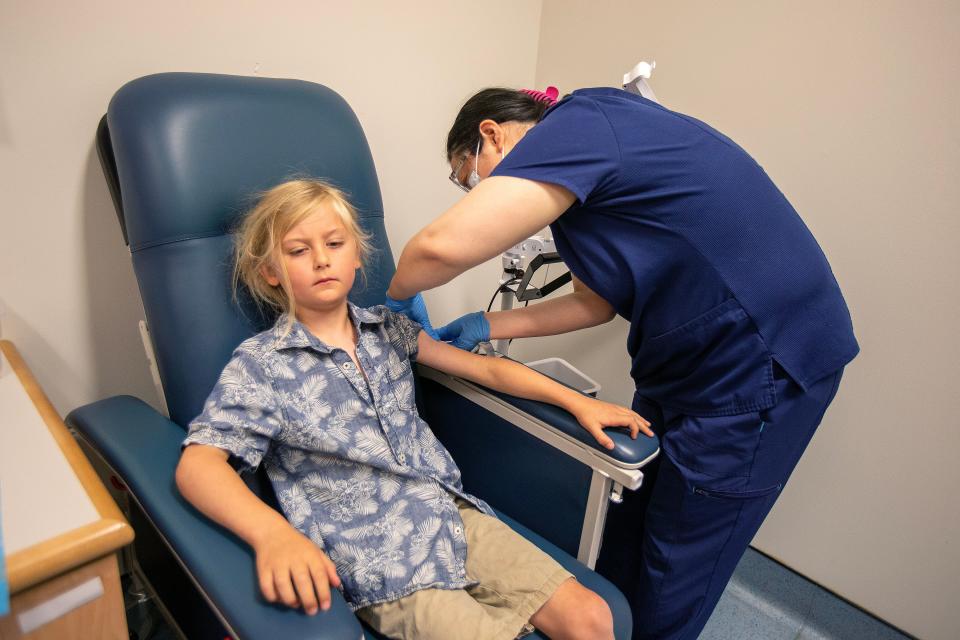 Seamus Naughton Mergner, 7, of Allentown participates in the Lyme disease clinical trial at the Pediatric Clinical Research Center, which is an academic clinical research center within the Department of Pediatrics at Rutgers Robert Wood Johnson Medical School, at the Child Health Institute of New Jersey in New Brunswick, NJ Thursday June 29, 2023. Fei Chen, RN, administers the injection.