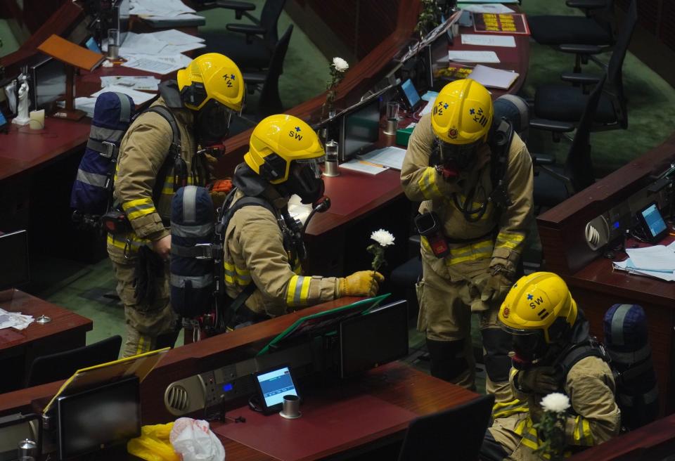 Firefighters check the main chamber of the Legislative Council after a pro-democracy lawmaker dropping a pot of a pungent liquid in the chamber in Hong Kong, Thursday, June 4, 2020. A Hong Kong legislative debate was suspended Thursday afternoon ahead of an expected vote on a contentious national anthem bill after pro-democracy lawmakers staged a protest. (AP Photo/Vincent Yu)