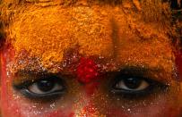 A young devotee, face smeared with turmeric powder, participates in a procession towards Golconda Fort during Bonalu festival in Hyderabad, India, Thursday, July 15, 2010. Bonalu is a month-long festival celebrated in Andhra Pradesh state and is dedicated to the Hindu Goddess of power Kali. (AP Photo/Mahesh Kumar A.)