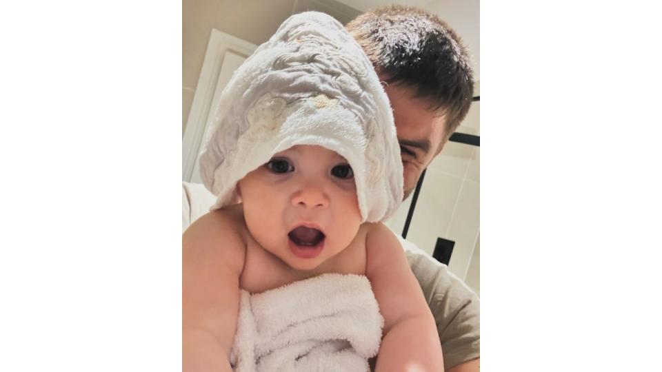 father holding daughter wrapped in towel 