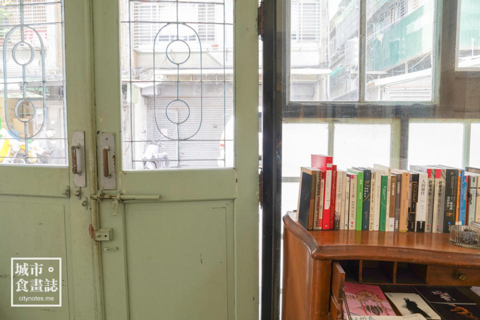 咖啡館的門是舊時代的木門，中間有扇玻璃窗，顏色是淺綠，非常典雅。 