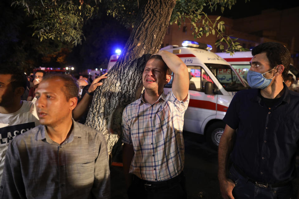 A man whose relative is on staff at Sina Athar Clinic weeps after its explosion, outside the clinic in Tehran, Iran, early Wednesday, July 1, 2020. Iranian state TV says an explosion from a gas leak in a medical clinic in northern Tehran has killed multiple people. (AP Photo/Vahid Salemi)