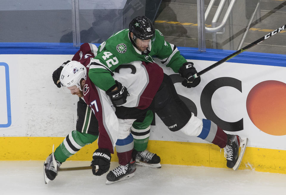 Dallas Stars defenseman Taylor Fedun (42) is checked by Colorado Avalanche left wing J.T. Compher (37) during the second period of Game 3 of an NHL hockey second-round playoff series, Wednesday, Aug. 26, 2020, in Edmonton, Alberta. (Jason Franson/The Canadian Press via AP)