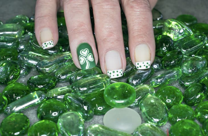 st patricks day inspired nail art with a shamrock and green and white polka dots