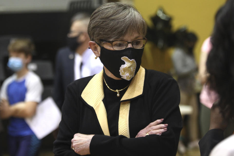 In this Monday, May 17, 2021, photo, Kansas Gov. Laura Kelly tours a COVID-19 vaccination clinic for students aged 12 through 15 set up in a gym at Topeka High School in Topeka, Kan. The Democratic governor is under increasing pressure to end an extra $300 a week in benefits for unemployed workers, with critics of the aid arguing that businesses are having problems hiring enough workers because of it. (AP Photo/John Hanna)