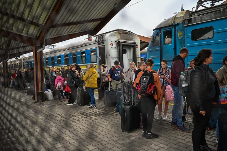 Ukrainian refugees carry their bags as they get off a train on Sept. 30