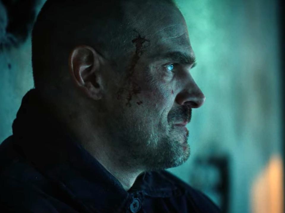 hopper in prison in russia in stranger things 4, with a marked up face and shaved head