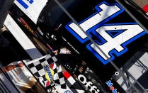 LAS VEGAS, NV - MARCH 11: Tony Stewart, driver of the #14 Mobil 1/Office Depot Chevrolet, gets handed the checkered flag by a NASCAR official after winning the NASCAR Sprint Cup Series Kobalt Tools 400 at Las Vegas Motor Speedway on March 11, 2012 in Las Vegas, Nevada. (Photo by Tom Pennington/Getty Images)