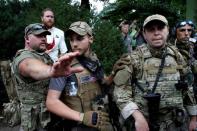 Un supremacista blanco está parado atrás de miembros de una milicia después de un enfrentamiento con contramanifestantes en Charlottesville, Virginia, Estados Unidos. 12 de agosto, 2017. REUTERS/Joshua Roberts