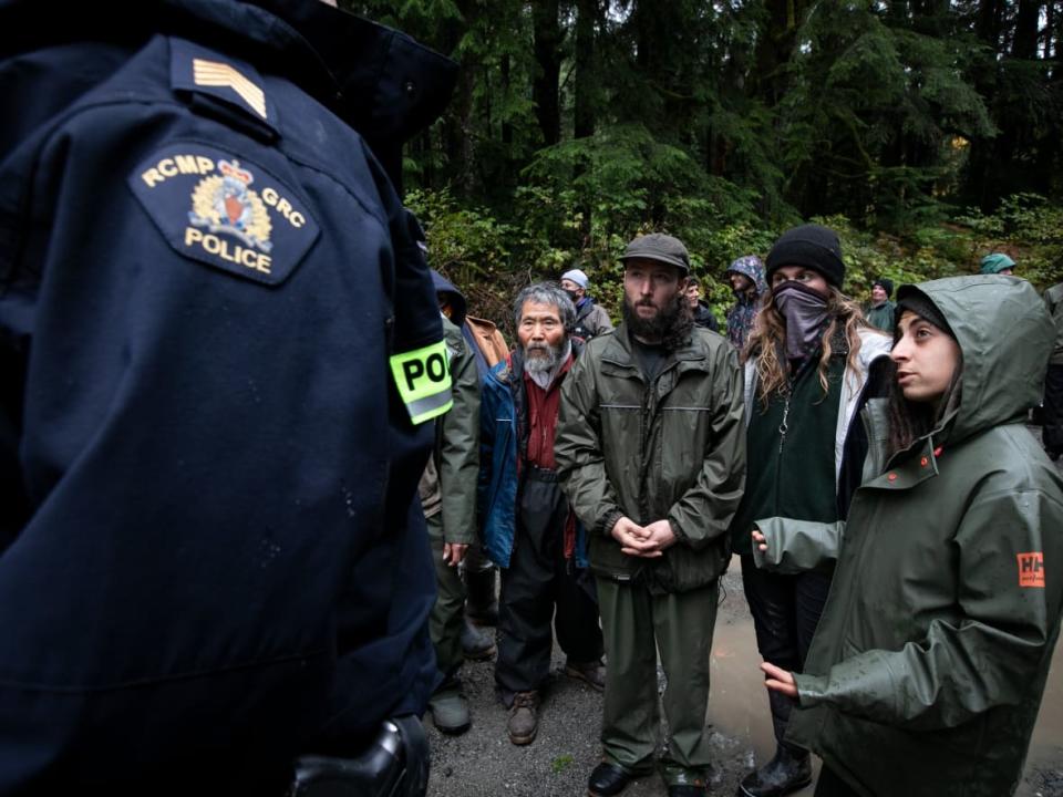 Protesters argue with police at one of the main anti old-growth logging protest sites on Sept. 30, 2021, just after a judge had quashed an injunction that banned protesters from blocking logging work. That ruling has now been overturned.  (Ken Mizokoshi/CBC - image credit)