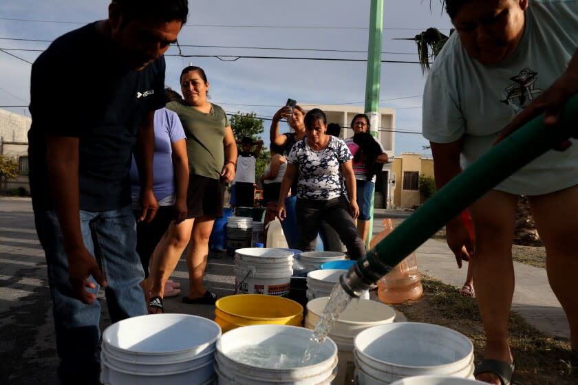 GARCIA, NUEVO LEON - JULY 19: Residents wait in line for not potable water delivered by a tanker truck in Colonia Mirador de Garcia on Tuesday, July 19, 2022 in Garcia, NUEVO LEON. Residents have been without running water for days. A truck carrying more than 4,000 gallons of not potable is distributed to residents. The water is used to flush the toilet, launder clothing, wash dishes or bathe. People rely on bottled water bought from the store to cook and drink. Garcia is a municipality located to the northwest of the Monterrey metropolitan area. Nuevo Leon, one the wealthiest states in Mexico, is facing an unprecedented water crisis, with the taps running dry in parts of Monterrey and the surrounding areas. Authorities blame a four-year drought that has almost completely dried up dams and a history of poor water management. Residents have only had water run from their taps for a few hours each day. (Gary Coronado / Los Angeles Times)