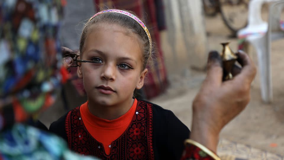 A Palestinian woman Hadeya Qudaih applying traditional kohl eyeliner to her granddaughter in Khan Younis in the southern Gaza Strip in March 2020. - Majdi Fathi/NurPhoto/Getty Images