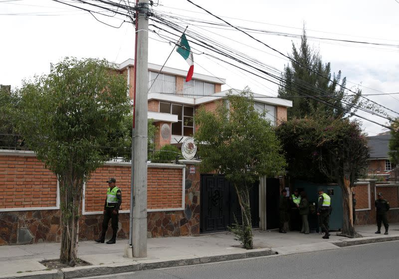 Police officers stand guard next to Mexico's embassy in La Paz