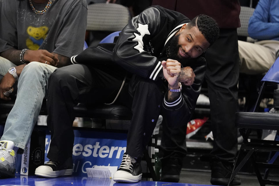 NLF football free agent Odell Beckham Jr. gestures while sitting court side during the first half of an NBA basketball game between the Phoenix Suns and Dallas Mavericks in Dallas, Monday, Dec. 5, 2022. (AP Photo/LM Otero)