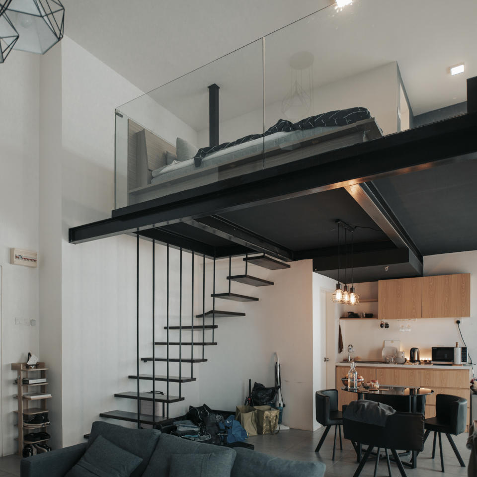 Black floating staircase leading up to a loft space