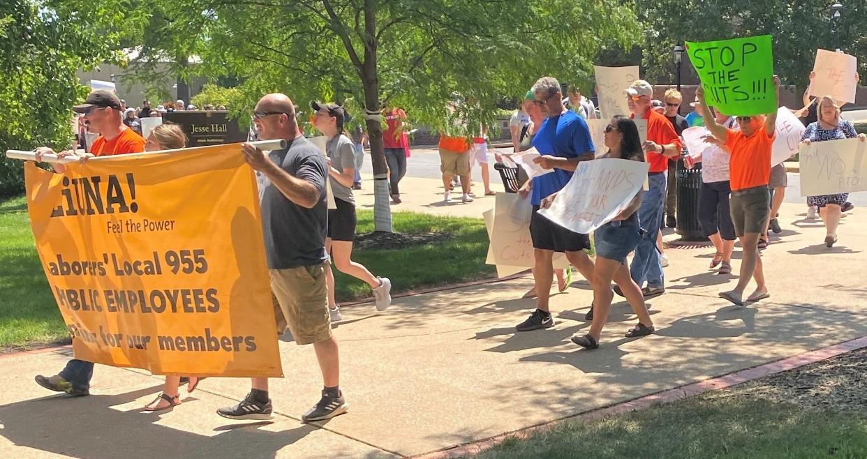 Members of the University of Missouri workers' union on Saturday march from Speakers Circle to the Columns on Francis Quadrangle as part of their rally protesting the UM System's proposal for paid time off.