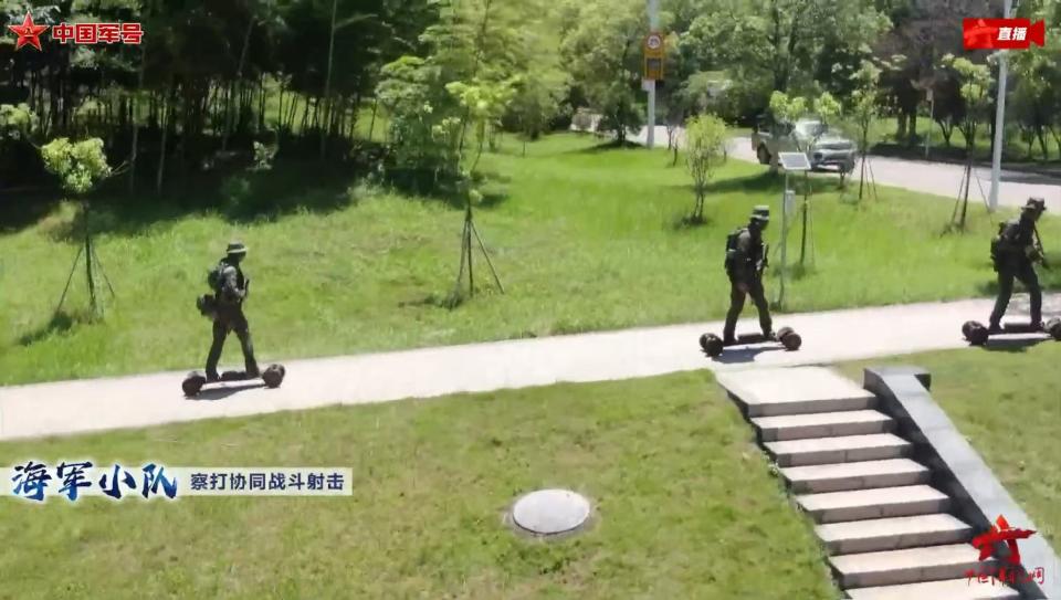 Chinese soldiers ride electric skateboards on an asphalt road.