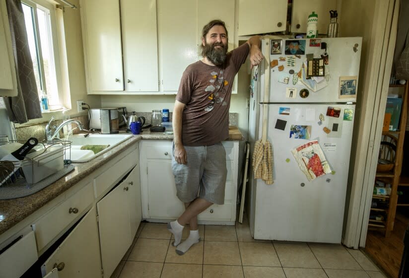 LOS FELIZ, CA-MAY 16, 2022: Josh Steichmann, 43, is photographed next to his refrigerator located inside the kitchen of his apartment in Los Feliz. The prior tenant left it there so Steichmann was relieved that he didn't have to search for one himself. (Mel Melcon / Los Angeles Times)