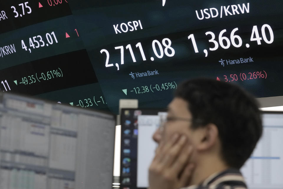 A currency trader watches monitors near the screen showing the Korea Composite Stock Price Index (KOSPI) and the foreign exchange rate between U.S. dollar and South Korean won, right, at the foreign exchange dealing room of the KEB Hana Bank headquarters in Seoul, South Korea, Thursday, May 23, 2024. (AP Photo/Ahn Young-joon)