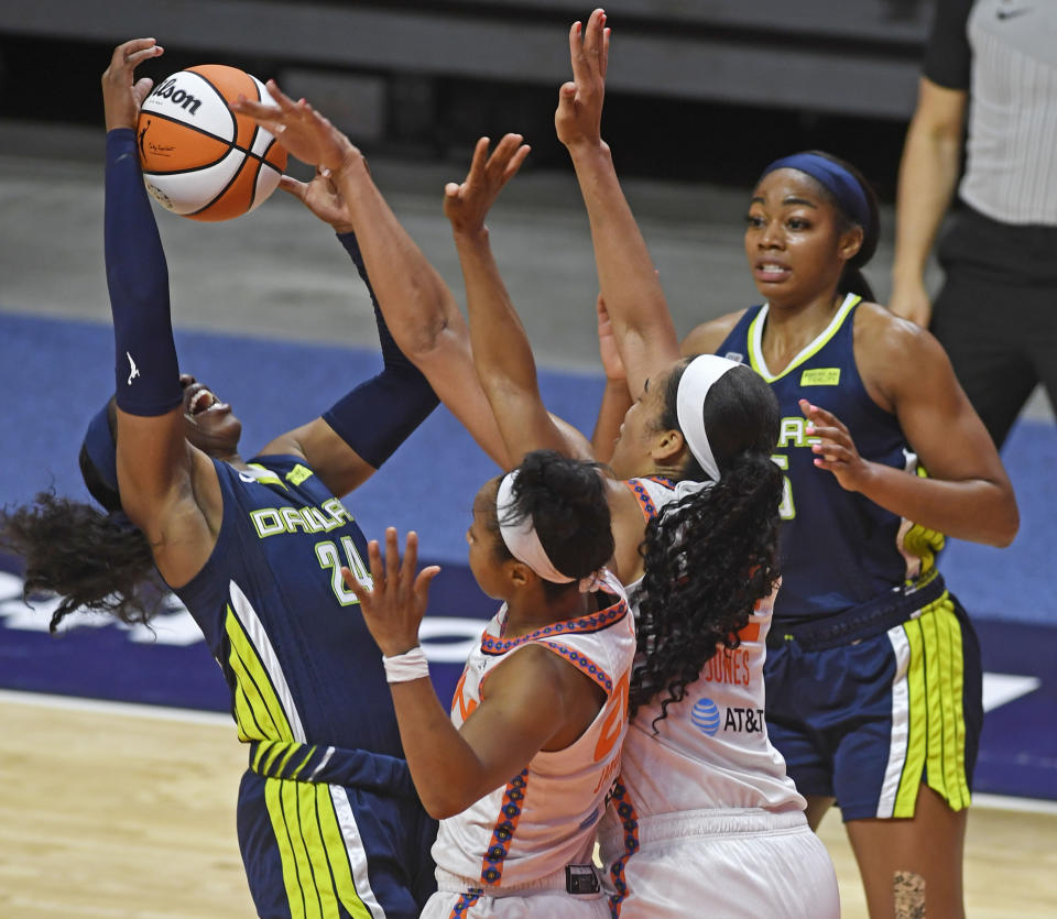 Connecticut Sun guard Briann January, center, commits the foul on Dallas Wings guard Airka Ogunbowale during a WNBA basketball game Tuesday, June 22, 2021 at Mohegan Sun Arena in Uncasville, Conn. (Sean D. Elliot/The Day via AP)