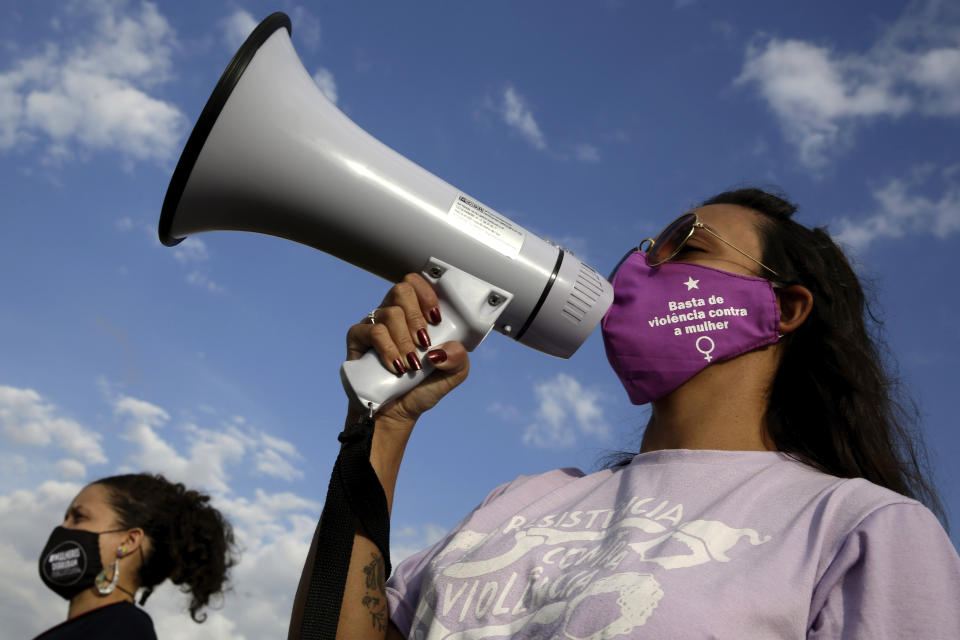 Women's movement activists protest against the government's inefficiency in the face of the new coronavirus pandemic and the ongoing police brutality against blacks, in front of the National Congress, in Brasilia, Brazil, Thursday, July 2, 2020. (AP Photo/Eraldo Peres)