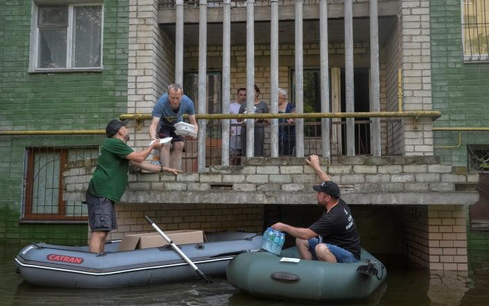 Volunteers deliver food to local residents in a flooded area after the Nova Kakhovka dam breached, amid Russia's attack on Ukraine, in Kherson, Ukraine June 9, 2023. REUTERS/Oleksandr Klymenko - REUTERS/Oleksandr Klymenko