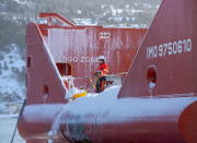 A crew member plows snow off the stern of the offshore supply ship Atlantic Shrike in St. John's Newfoundland on Saturday, Jan. 18, 2020. The state of emergency ordered by the City of St. John's is still in place, leaving businesses closed and vehicles off the roads in the aftermath of the major winter storm that hit the Newfoundland and Labrador capital. (Andrew Vaughan/The Canadian Press via AP)