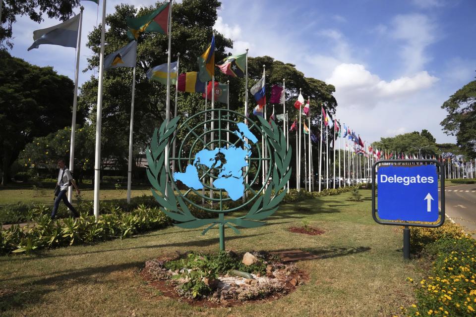 A person walks near flags at the United Nations Environment Programme headquarters in Nairobi, Kenya, on Wednesday, Feb. 21, 2024. The United Nations Environment Assembly is meeting in Nairobi on Monday, Feb. 26, to discuss how countries can work together to tackle environmental crises like climate change, pollution and loss of biodiversity. (AP Photo/Brian Inganga)