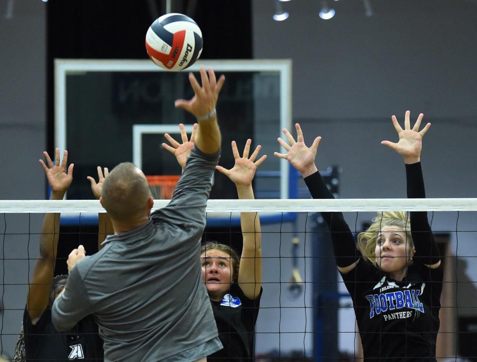 Abilene Christian High senior Halle Bruntmyer, right, defends at the net as Lady Panthers' coach Arnett McClure hits the ball during a drill in practice Monday at the ACHS gymnasium.