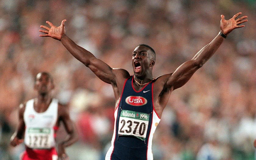 SP.OL.18.Track.0801.PM Michael Johnson reacts after crossing the finish line and winning the gold medal.