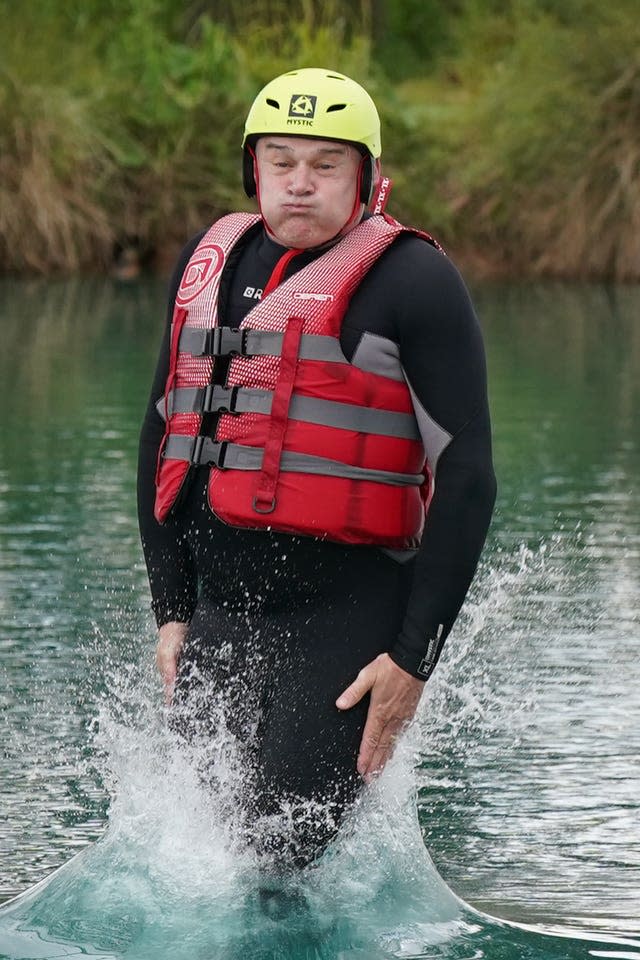 Liberal Democrats leader Sir Ed Davey jumping into the water as he attempts an Aqua Jungle floating assault course at Spot-On-Wake in Henley-in-Arden, Warwickshire