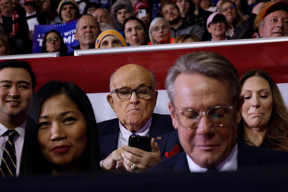Rudy Giuliani looking at his phone at a Trump rally