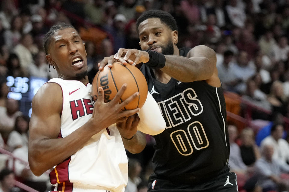 Miami Heat guard Josh Richardson (0) and Brooklyn Nets forward Royce O'Neale (00) battle for the ball during the first half of an NBA basketball game, Wednesday, Nov. 1, 2023, in Miami. (AP Photo/Wilfredo Lee)
