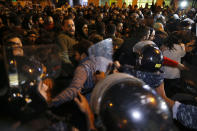 Riot police clash with protesters, as they try to remove them and open a road during an anti-government protest in Beirut, Lebanon, Wednesday, Dec. 4, 2019. Protesters have been holding demonstrations since Oct. 17 demanding an end to corruption and mismanagement by the political elite that has ruled the country for three decades. (AP Photo/Bilal Hussein)