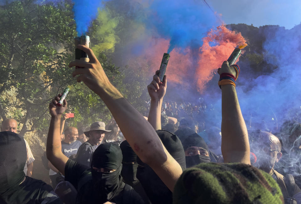 Lebanese-Armenian protesters hold flares, as they protest near the Azerbaijani Embassy, to denounce the Azerbaijani military offensive that recaptured Nagorno-Karabakh from the separatist Armenian authorities in the enclave, in Ain Aar, east of Beirut, Lebanon, Thursday, Sept. 28, 2023. (AP Photo/Hussein Malla)