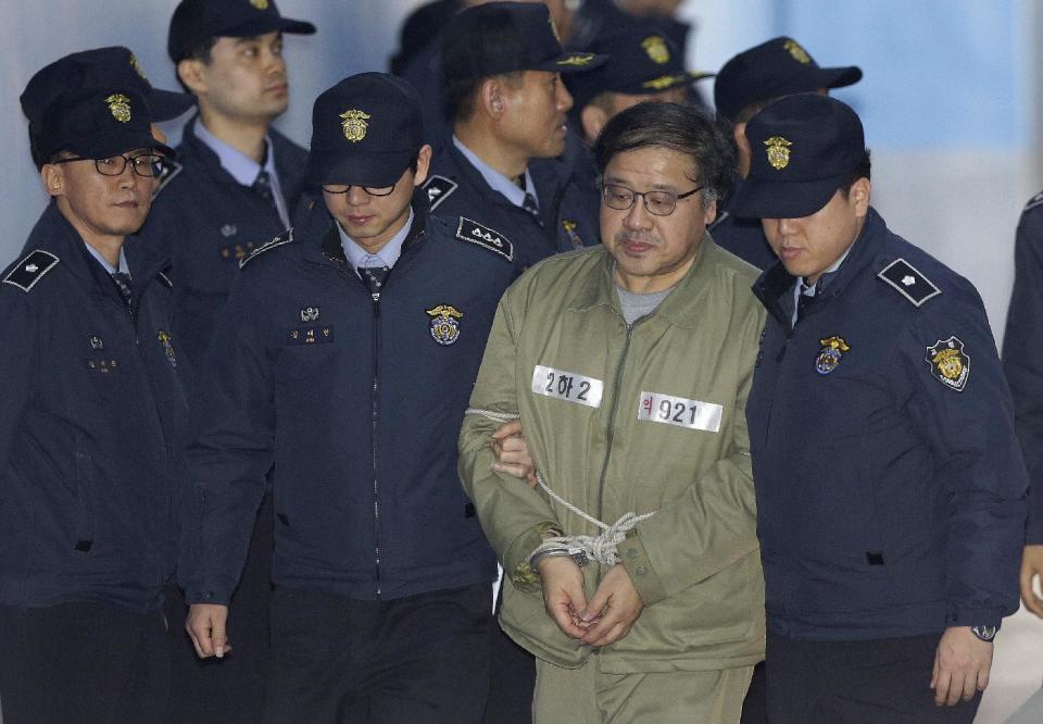 A former presidential secretary Ahn Jong-beom, second from right, arrives for his trial at the Seoul Central District Court in Seoul, South Korea, Thursday, Jan. 5, 2017. Ahn, Park Geun-hye's former senior secretary for policy coordination, allegedly directed former Health Minister Moon Hyung-pyo to pressure the National Pension Service to support a merger between two Samsung affiliates in 2015. (AP Photo/Ahn Young-joon)