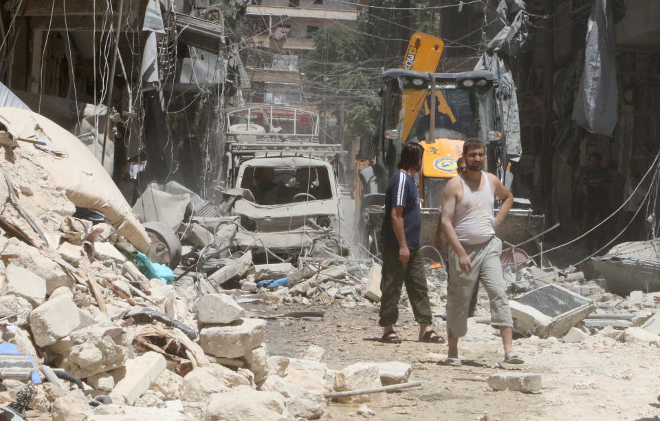 Residents inspect a damaged site after an airstrike on Aleppo's rebel held Al-Mashad neighbourhood, Syria on July 26, 2016.