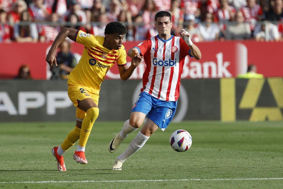 Barcelona's Lamine Yamal, left, challenges for the ball with Girona's Miguel Gutierrez during the Spanish La Liga soccer match between Girona and Barcelona, at the Montilivi stadium in Girona, Spain, Saturday, May 4, 2024. (AP Photo/Joan Monfort)